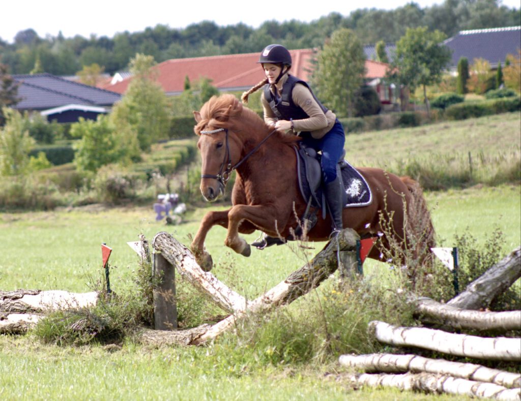Christine Loke springer på sin islandske hest Kiljan. 