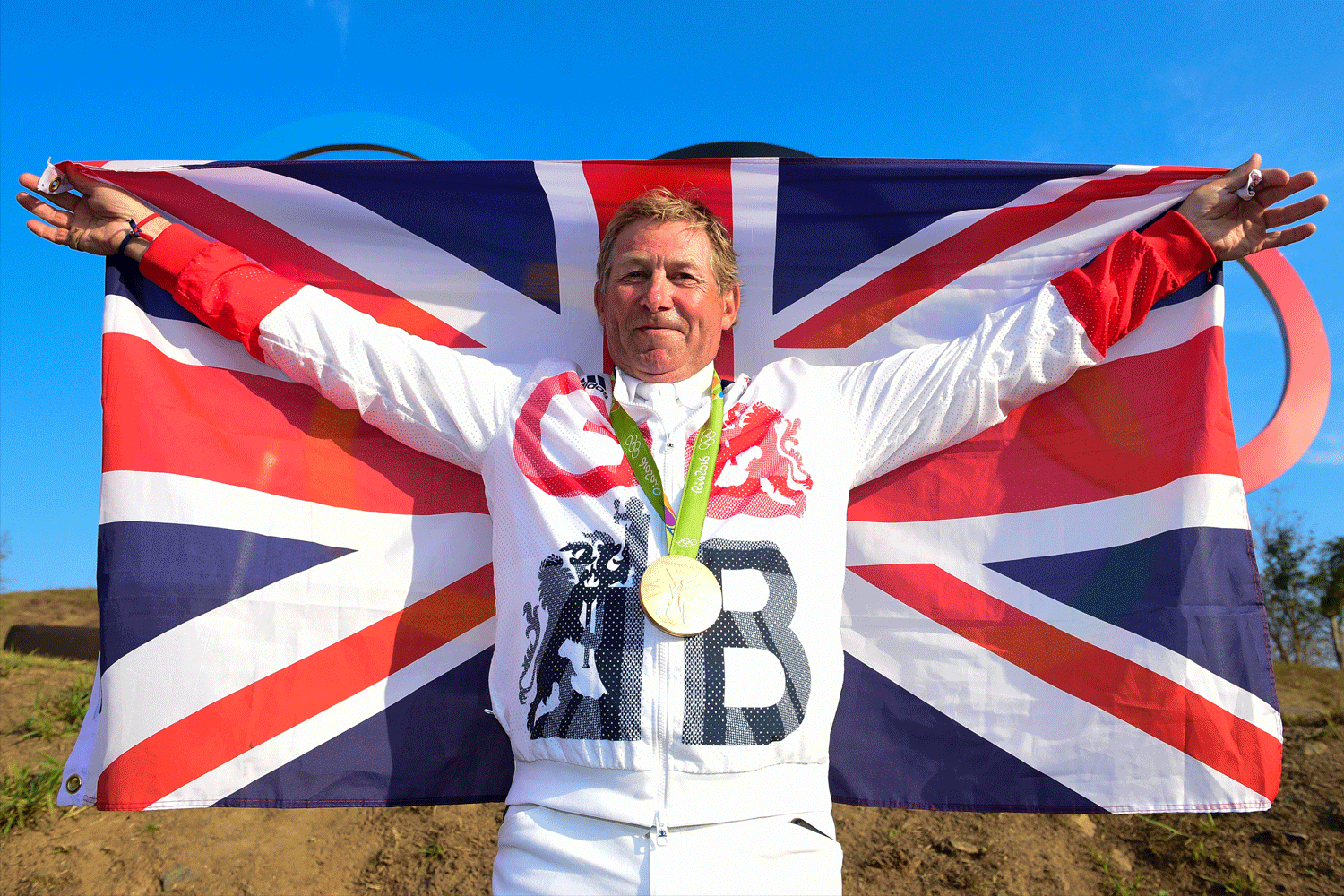 Nick Skelton hæver stolt det engelske flag efter sejren ved OL. 