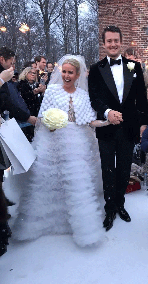 De glade nygifte Emilie og Christoffer Martinsen-Kønigsfeldt foran Høsterkøb Kirke.  
